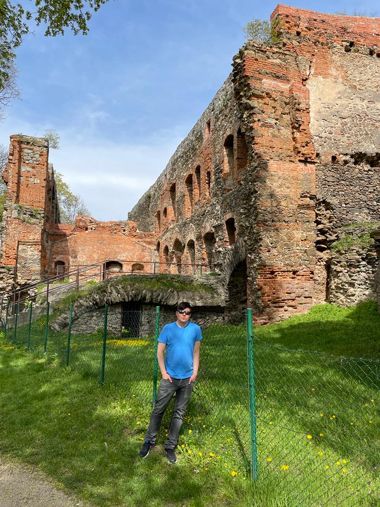 The author of the essay posing against the background of the imposing, albeit ruined Frankenstein's castle. 
